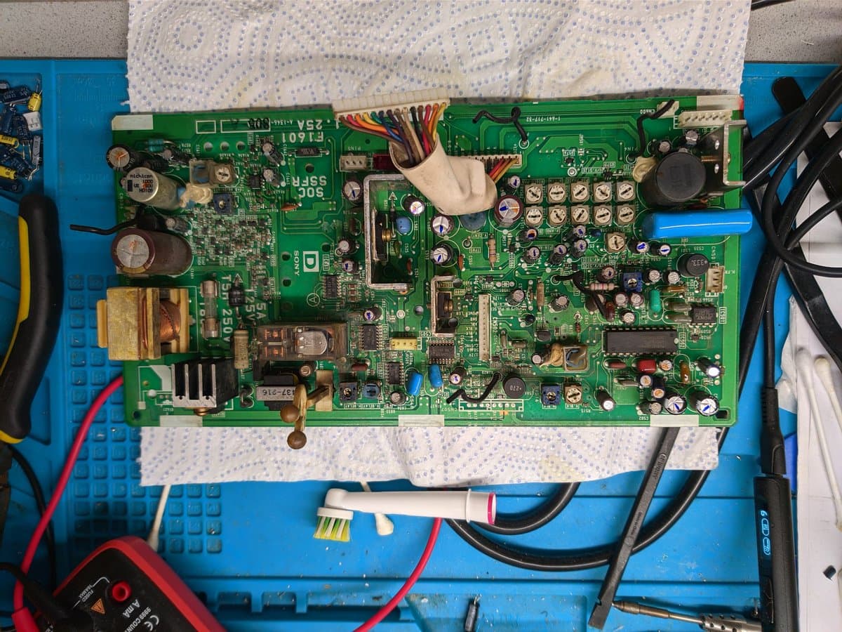 Sony BVM-9045QD deflection board with recapped electrolytic capacitors; old failed caps marked with dashes, new replacements with dots; oversized 1000uF capacitor visible.