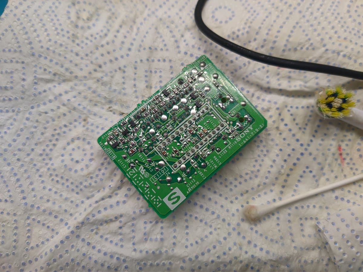 Sony BVM-9045QD colour board undergoing reflow soldering on workbench with soldering iron and flux.