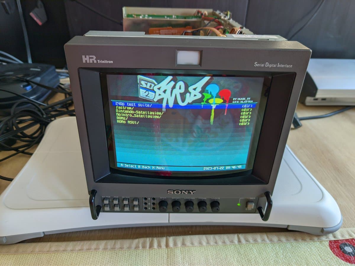 Sony BVM-9045QD displaying SNES test suite menu after restoration; Triton Serial Digital Interface unit visible above monitor on wooden desk.