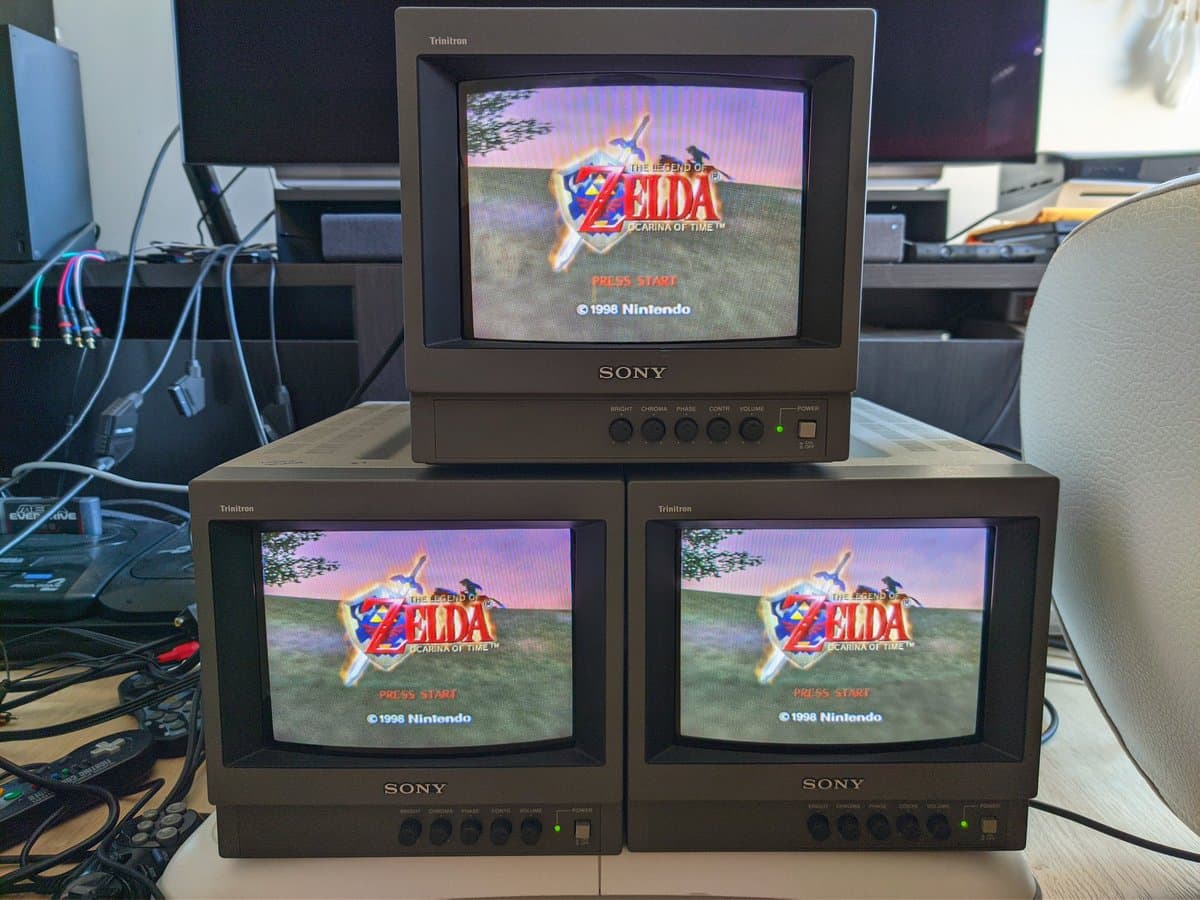 Three Sony PVM-9040 CRT monitors stacked displaying Legend of Zelda: Ocarina of Time start screen after trim potentiometer and ceramic capacitor replacement.