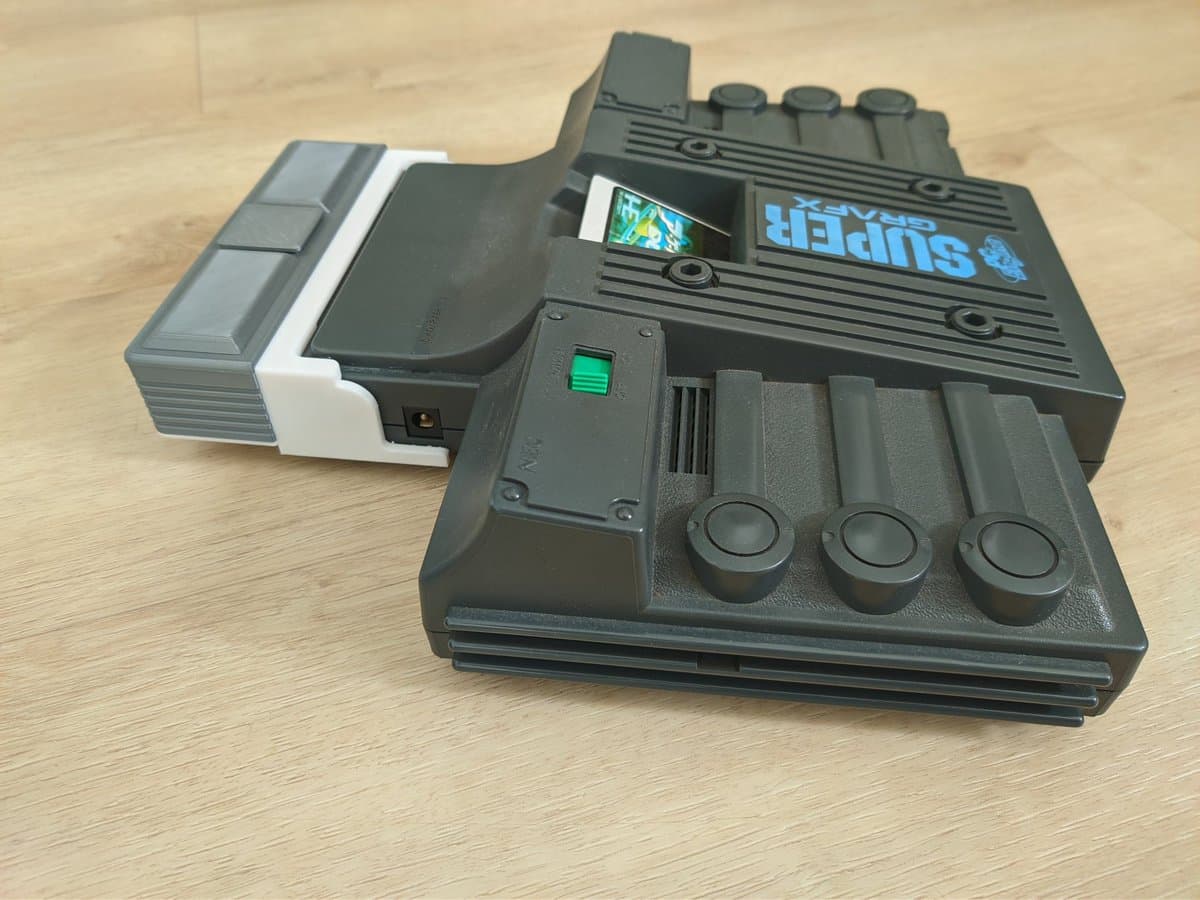 Refurbished NEC PC Engine SuperGrafx with EDFX module in mini-IFU shell, showing three control knobs and green power indicator on wooden surface.