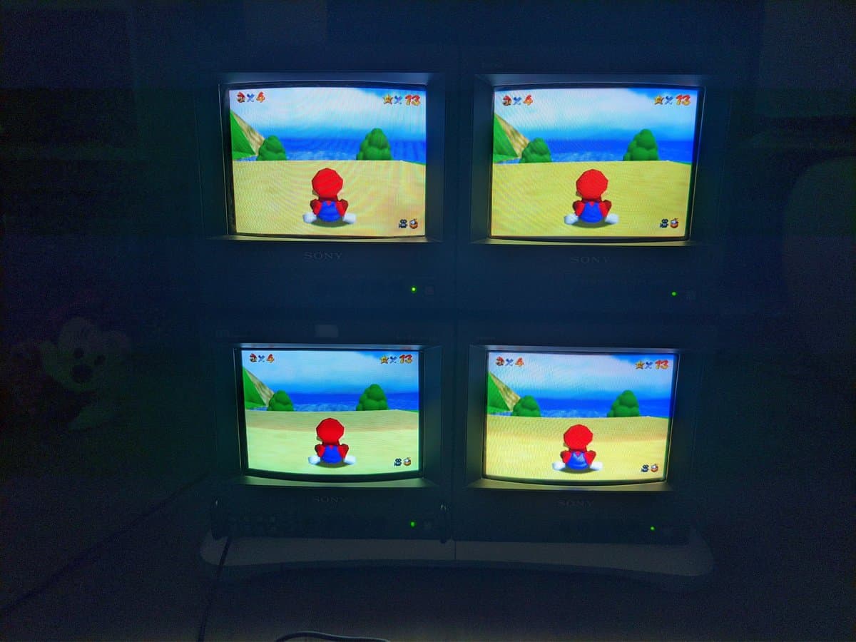 Four Sony CRT monitors displaying Super Mario 64 via S-video, showing color and resolution differences between 250TVL PVMs and 450TVL BVM models.