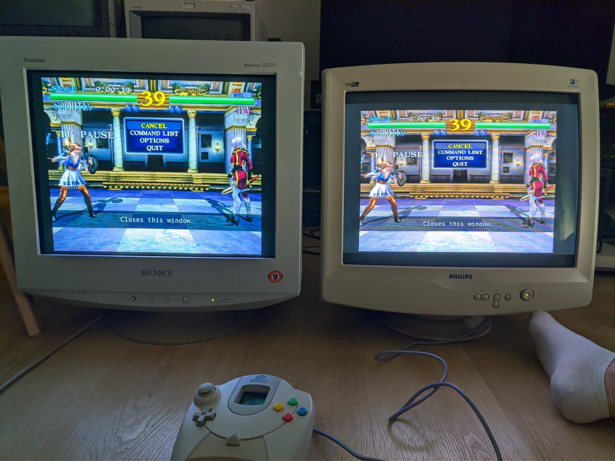 Two CRT monitors displaying Soul Calibur side-by-side: Sony aperture grille (left) vs Philips shadow mask (right), with Dreamcast controller below.