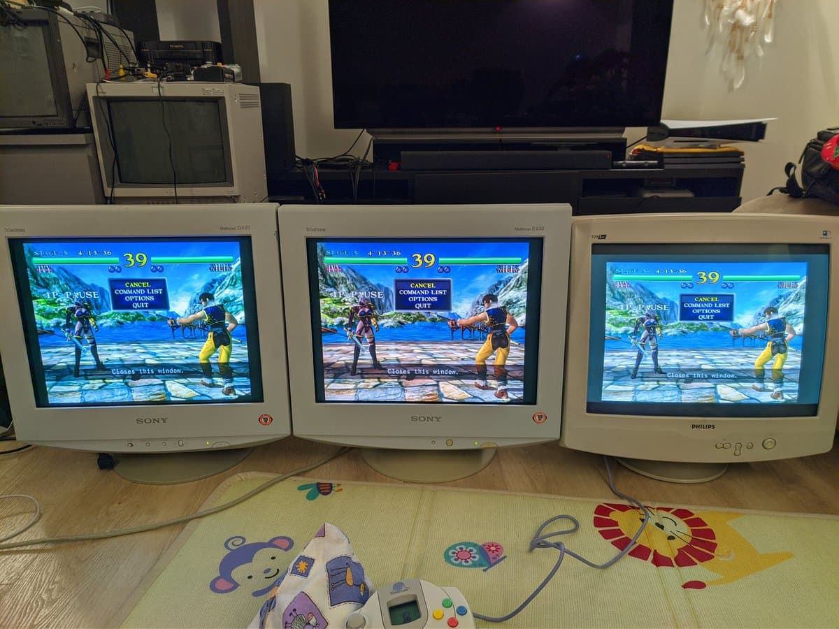 Three 19" PC CRTs displaying Soul Calibur arcade game: Sony G420 and E430 with Philips 109S4, controllers below on mat.