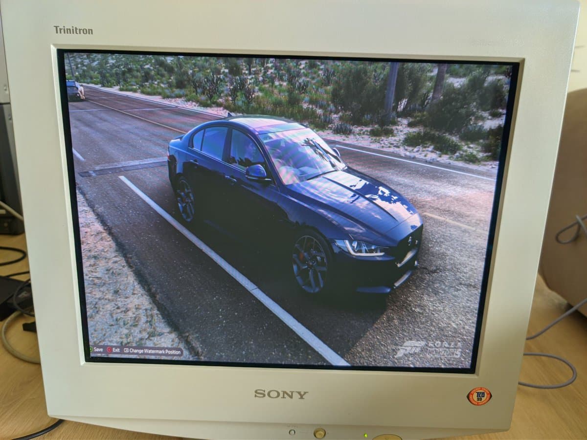 Sony CPD-E430 CRT displaying Forza Motorsport 5 at 1080p via Xbox Series X, showing blue sedan on mountain road.