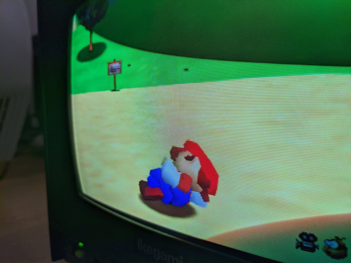 Sony BVM-D9H5J displaying Mario character on green grass. CRT tube showing aperture grille scanlines under restoration.