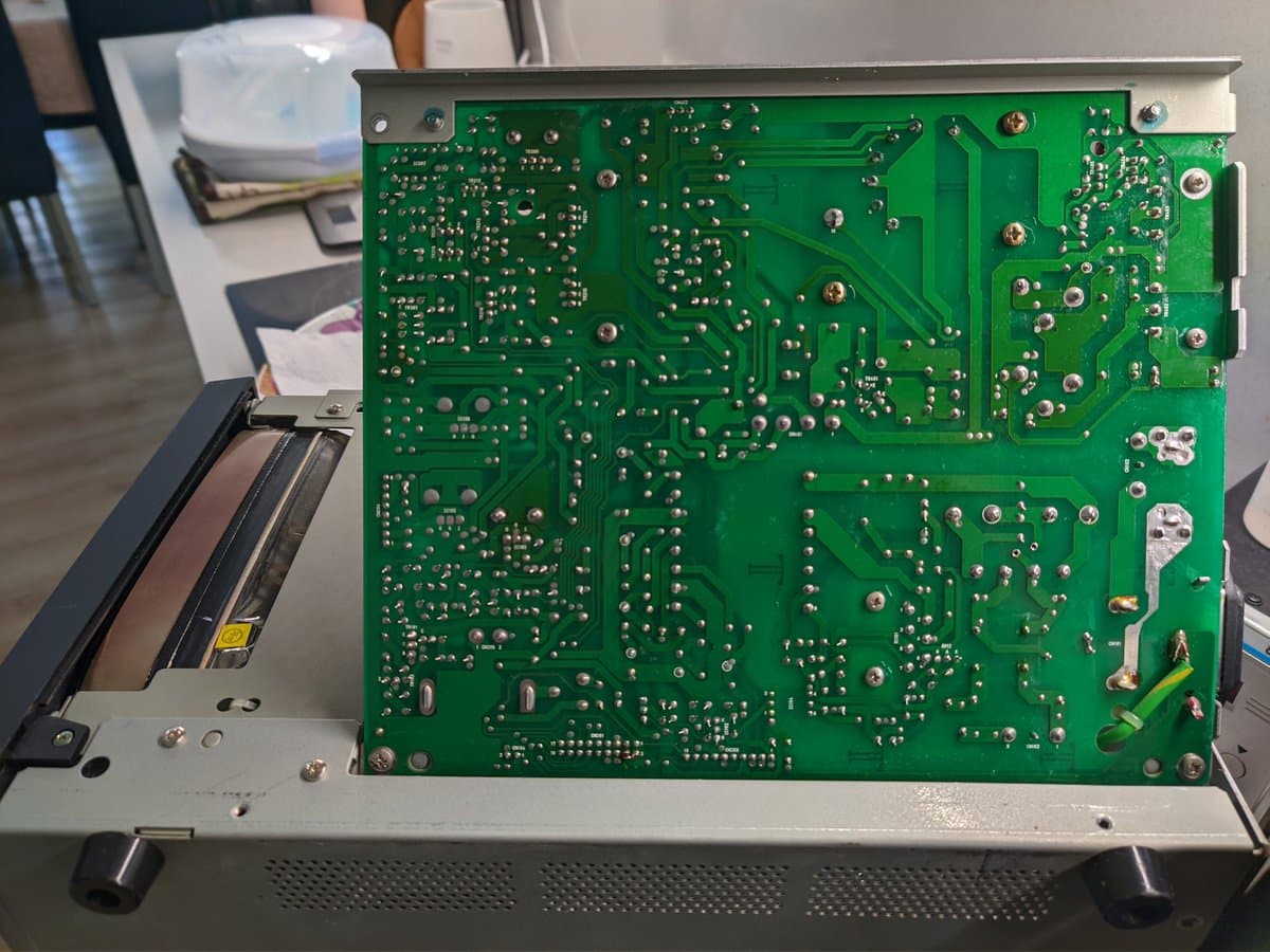 Ikegami TM10-17RA power supply PCB showing F101 fuse location and J101 jumper between large capacitors for 200-240V reconfiguration.