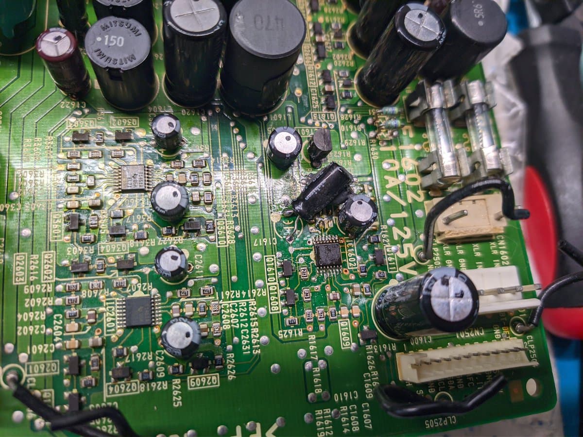 Close-up of Sony BVM-D9H5J PSU board showing reflowed solder joints, electrolytic capacitors, and residual flux residue from previous rework.