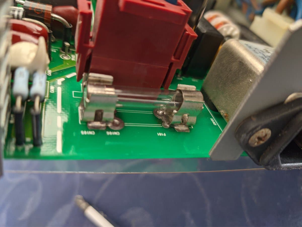 Close-up of Ikegami TM10-17RA PCB showing blown fuse and internal components after mechanical shock damage.