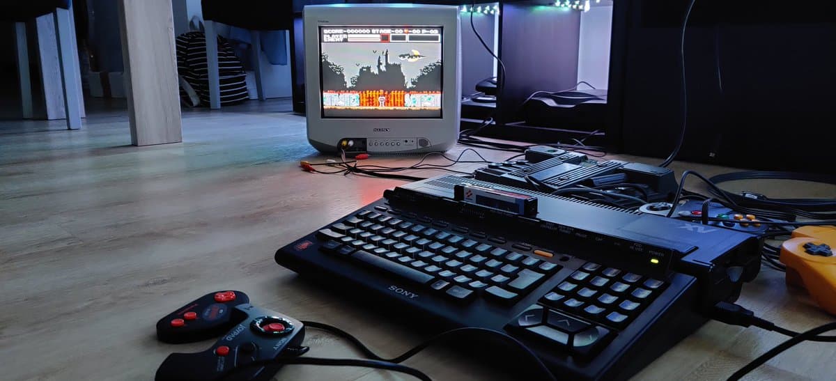Sony HB-F1XV MSX2+ displaying retro game on CRT monitor with controller and keyboard visible on workspace during restoration project.