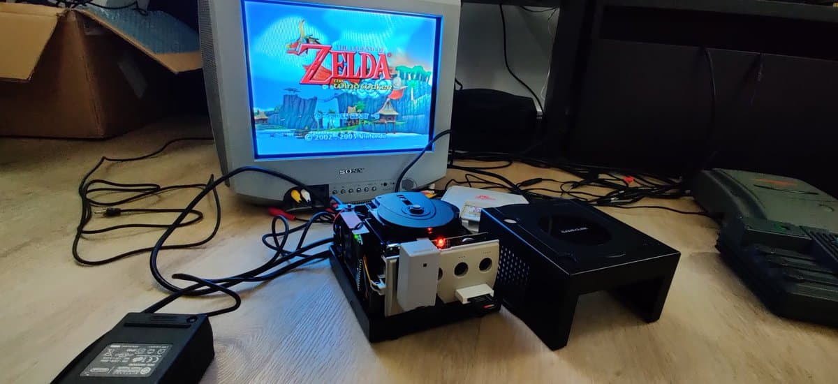 GameCube displaying Zelda Wind Waker title screen, connected to WiiKey storage interface and PicoBoot mod board with blue casing.