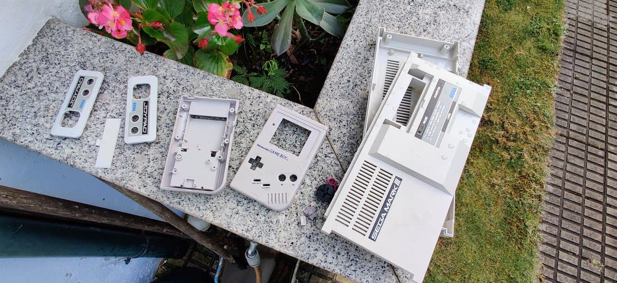 Disassembled Nintendo Game Boy DMG showing retrobrighted plastic shell components and internal parts laid out on concrete surface.