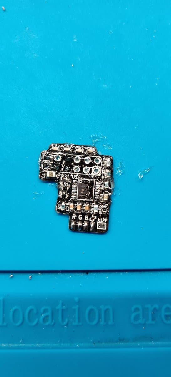 Assembled N64 RGB amp PCB on bright blue surface, showing soldered video IC and cleaned board post-rework.