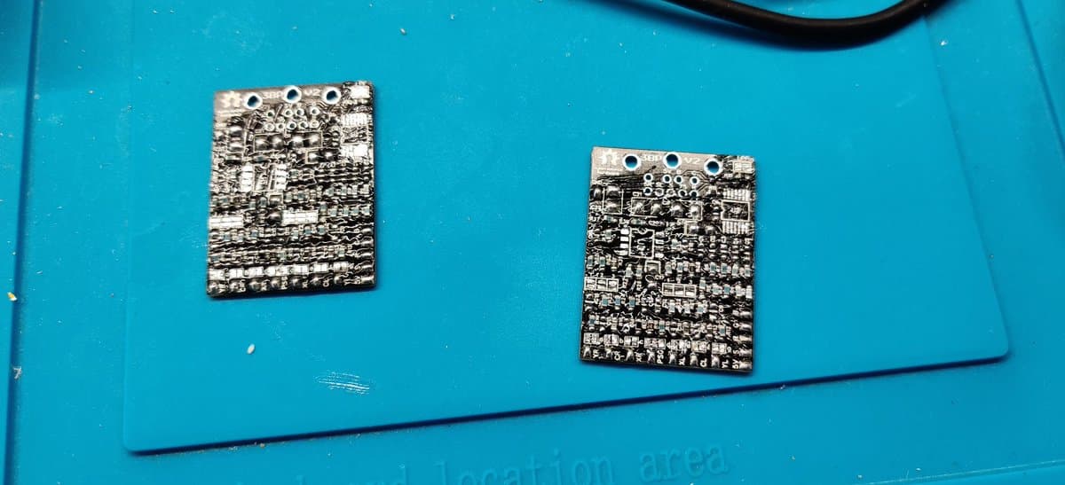 Two assembled circuit boards with solder joints and components mounted on turquoise surface; 3BP mod assembly complete.