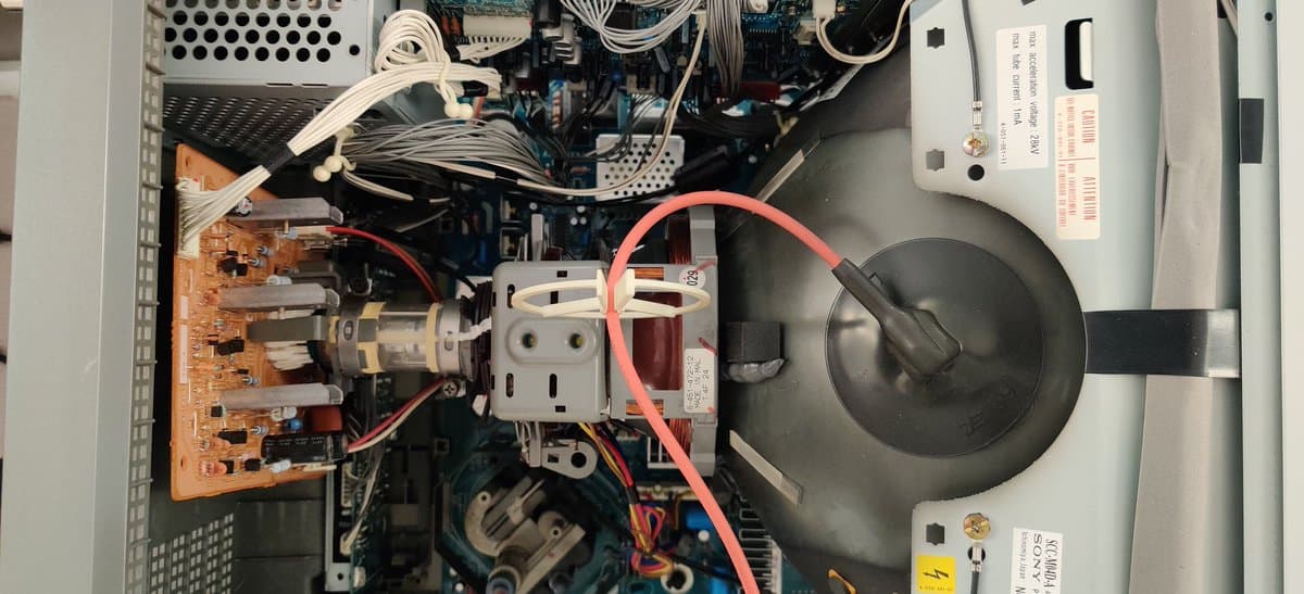 Interior view of Sony PVM-14L2 showing clean chassis, orange PCB on left, capacitors in good condition, and minimal dust accumulation indicating recent maintenance.