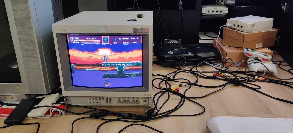 Sega Mega Drive II displaying Castlevania Bloodlines on CRT monitor, connected to test setup with controllers and cables visible on workbench.