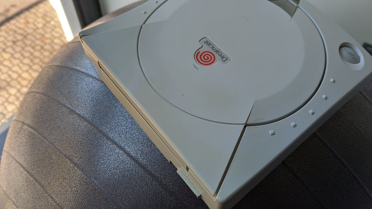 White Sega Dreamcast VA0 console with disc tray open, displaying the GDEMU mod installed in the optical drive bay.