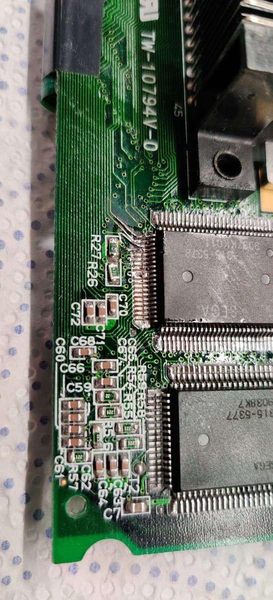 Close-up of Game Gear PCB showing capacitor damage from electrolyte corrosion, with labeled components C59, C68, C6, C7 and two large RAM chips with corroded solder joints.