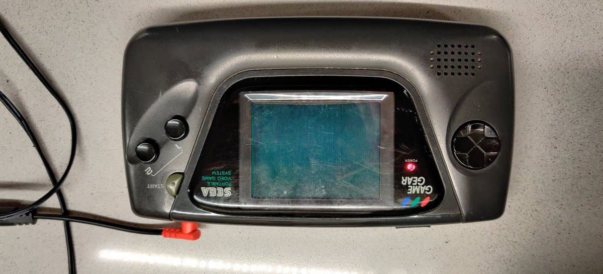 Sega Game Gear displaying corrupted screen output with visible horizontal line defects after electrolyte damage restoration attempt.