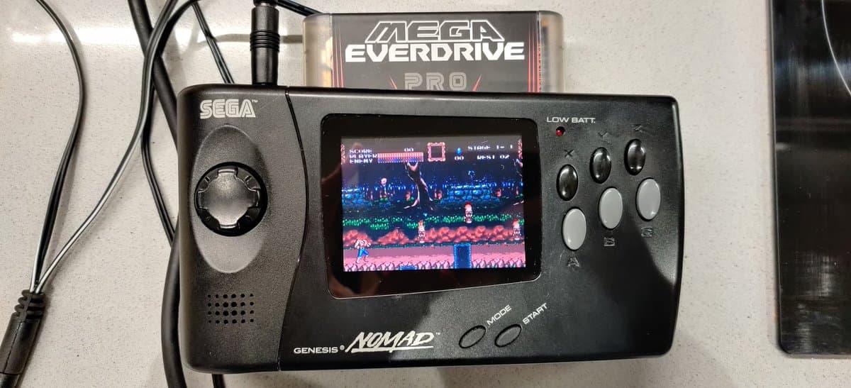 Sega Nomad displaying Sonic the Hedgehog with Mega Everdrive Pro cartridge inserted; repaired screen showing stable video output after solder joint restoration.