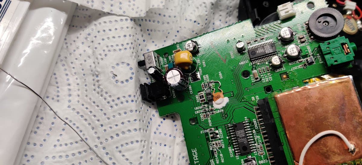 Sega Nomad circuit board with fresh capacitors installed, cleaned solder joints around power section and components, copper heatsink visible.