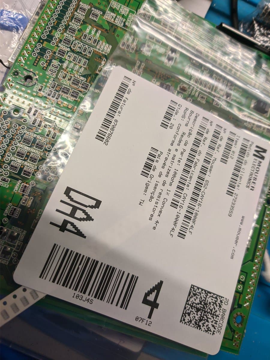 Dreamcast VA0 motherboard with GDEMU mod installation; close-up of labeled components and green PCB during refurbishment work.