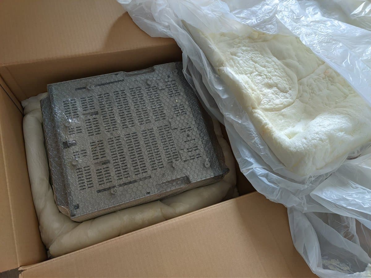 Sony PVM-14M4J CRT monitor packed in cardboard box with foam padding and plastic wrap, showing metal chassis with perforated panel and protective packaging materials.