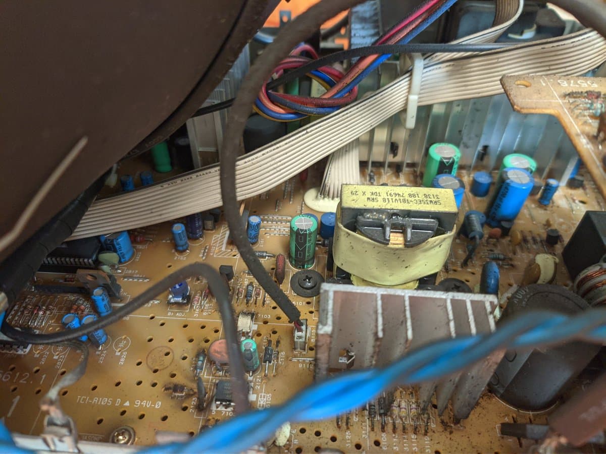 Dusty PCB interior of Philips 109S4 monitor showing capacitors, transformer, and ribbon cables with visible nicotine residue buildup on components.