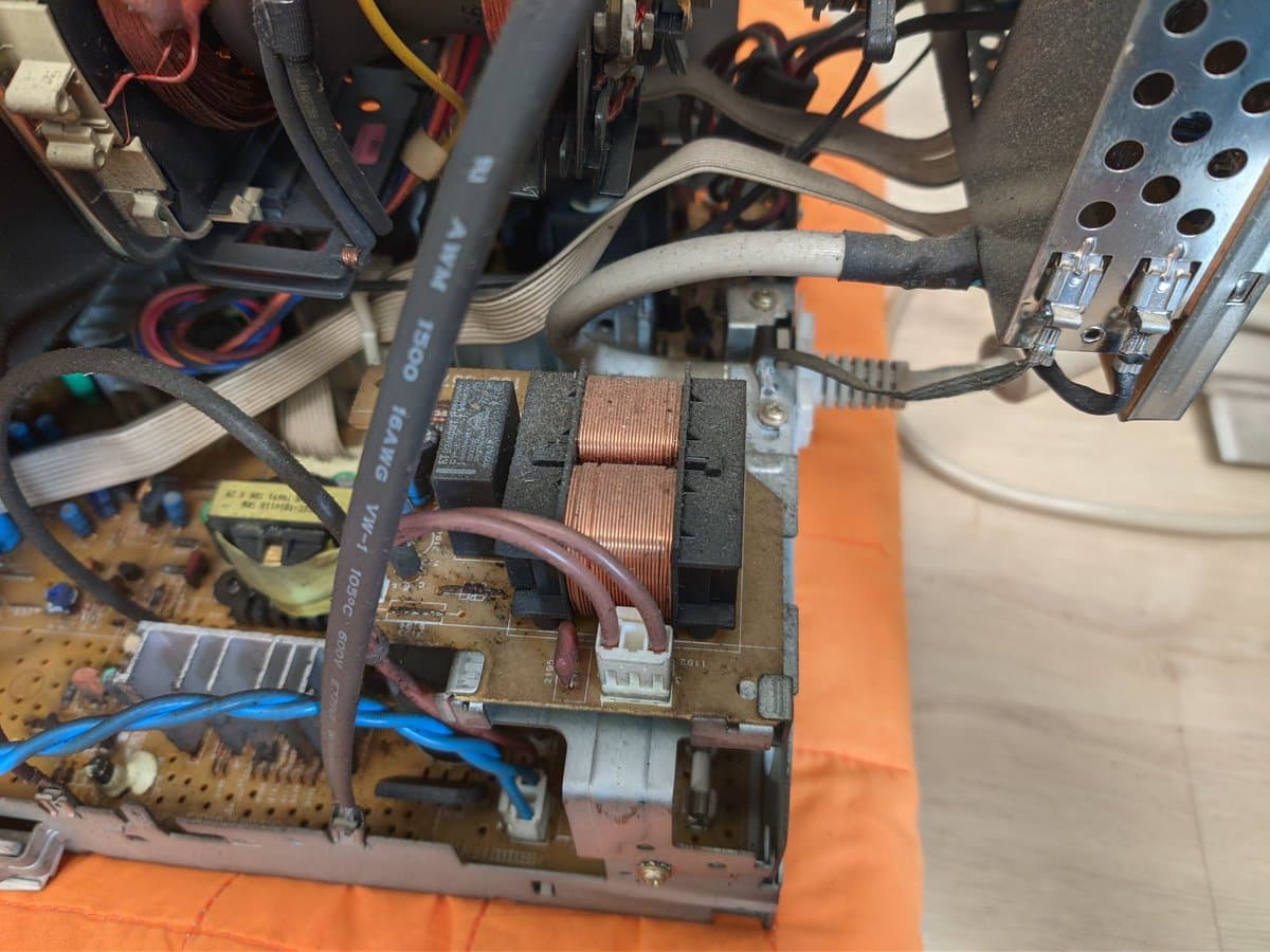 Philips 109S4 monitor internal view showing transformer, deflection coils, and circuit board with nicotine residue during restoration work.