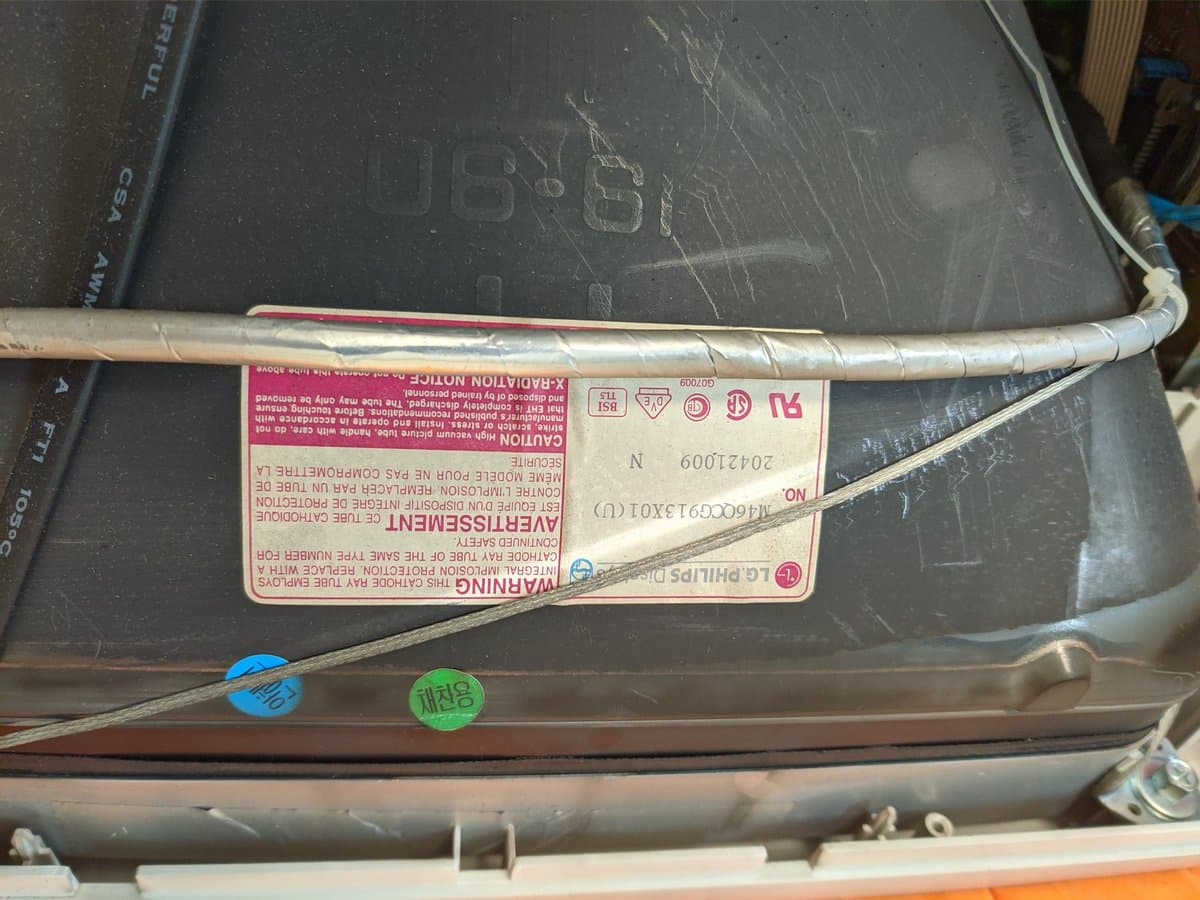 Philips 109S4 monitor interior showing heavy nicotine staining on deflection coil and circuitry during cleaning restoration.