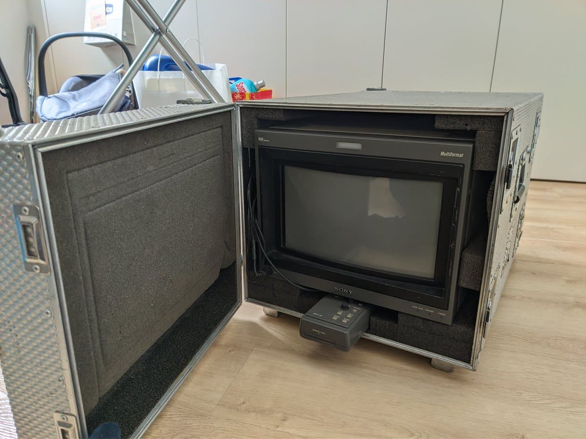 Sony BVM-D14H1E professional CRT monitor displayed in protective flight case with foam padding and remote control visible.