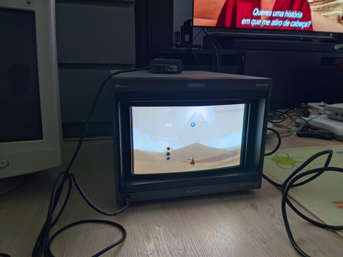 Sony BVM-D14H1E CRT displaying Journey game on PS3, desert landscape with character visible on screen in repair workspace.