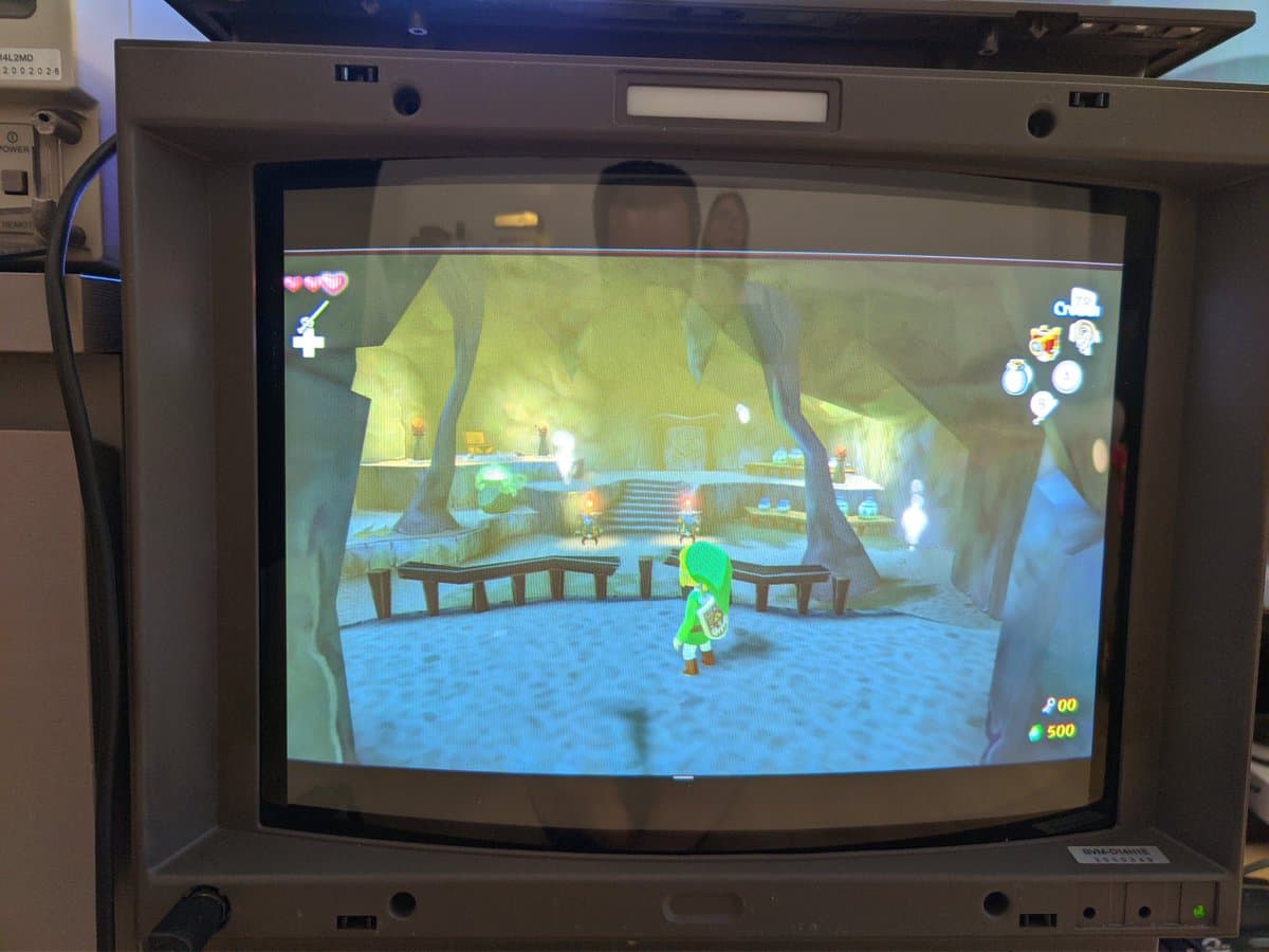 Wind Waker HD displayed on Sony BVM-D14H1E professional CRT monitor, showing forest village scene with green-clad character at 1080i resolution.