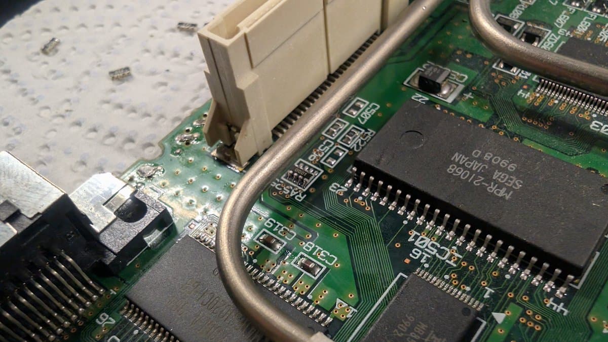 Dreamcast motherboard with GDEmu installed and resistor dummy load soldered to power supply connections for 100V PSU testing.