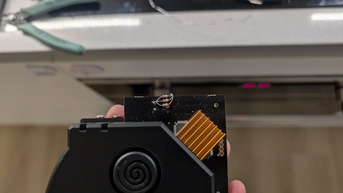 GDEmu board with gold flex connector and resistor dummy load installed in Dreamcast VA0 motherboard during Japanese unit refurbishment.