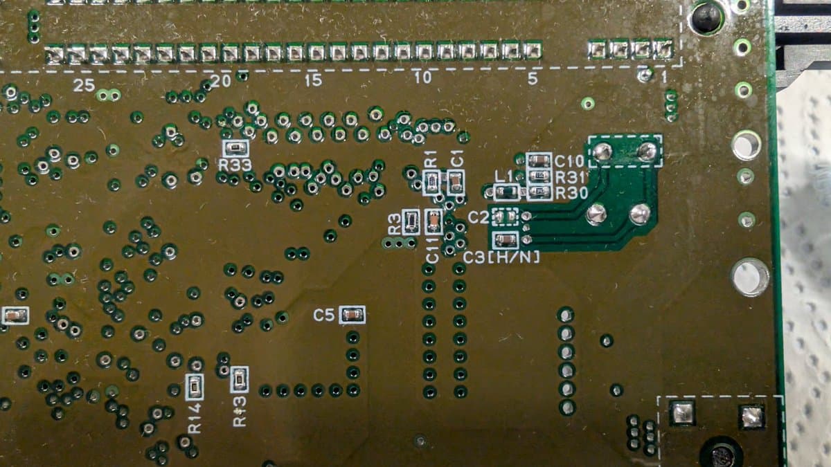 Close-up of Super Famicom Jr. motherboard showing replaced capacitors, resistors R33, R30, R31, C10, and other components for brightness and ghosting fixes.