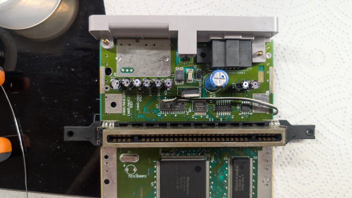Super Famicom Jr. motherboard showing recapped power section, brightness/ghosting mod components, and clean solder joints after restoration work.