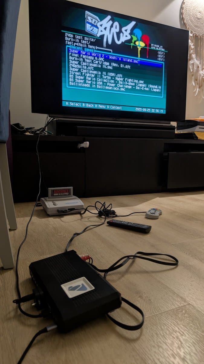 Super Famicom Jr. displaying test menu on TV via S-video through Tink4K Pro upscaler, with power supply and controller on wooden surface.