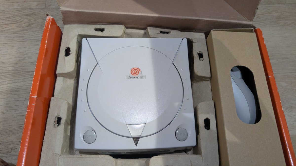 Dreamcast console in protective foam packaging with controller visible in cutout, ready for shipment after refurbishment.