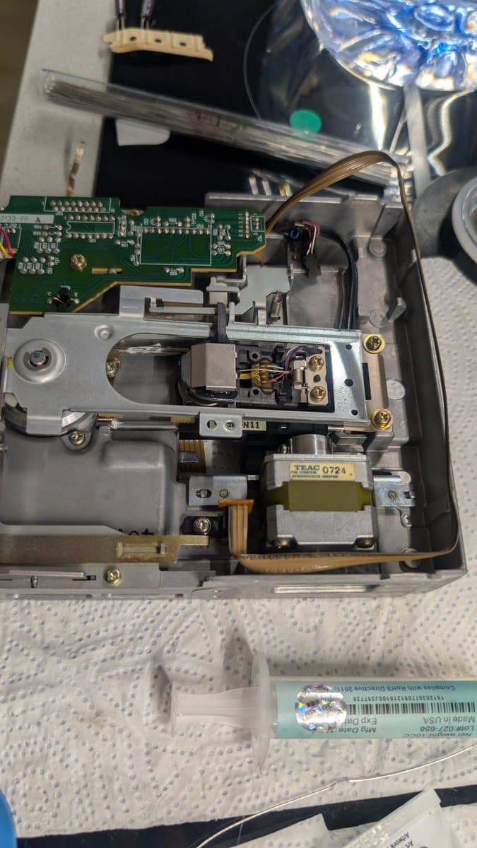 Sharp X68000 Pro II open chassis showing recapped power supply board with TEAC transformer, green PCB, and cleaned floppy drive mechanism during restoration.