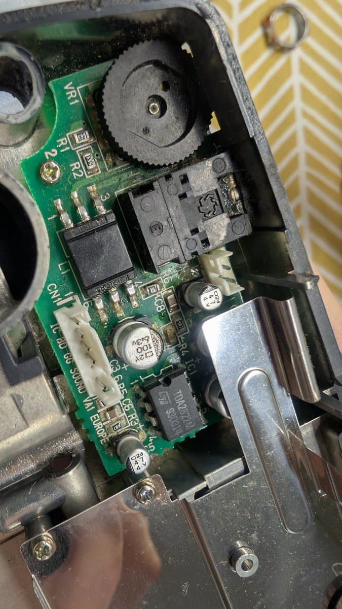 Sega Game Gear circuit board with corroded components, leaking capacitors, and dangerously improvised PSU wiring creating fire hazard.