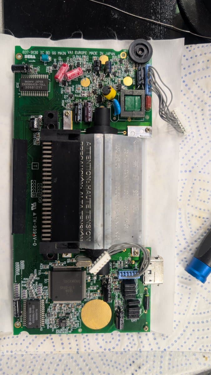 Sega Game Gear main PCB with replaced capacitors and cleaned solder joints on IC components and power regulation circuitry.