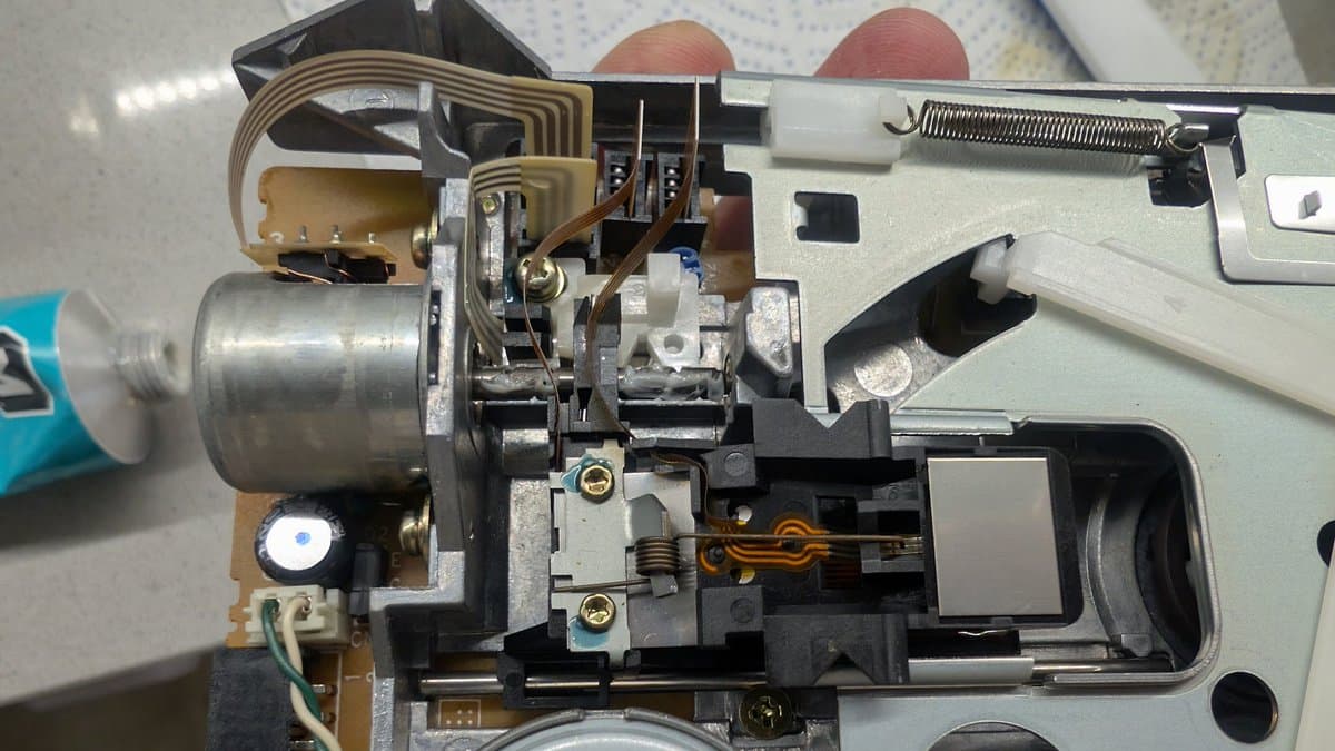 FM Towns Marty floppy drive mechanism disassembled, showing motor, head assembly, and belt path with melted belt remnants visible.