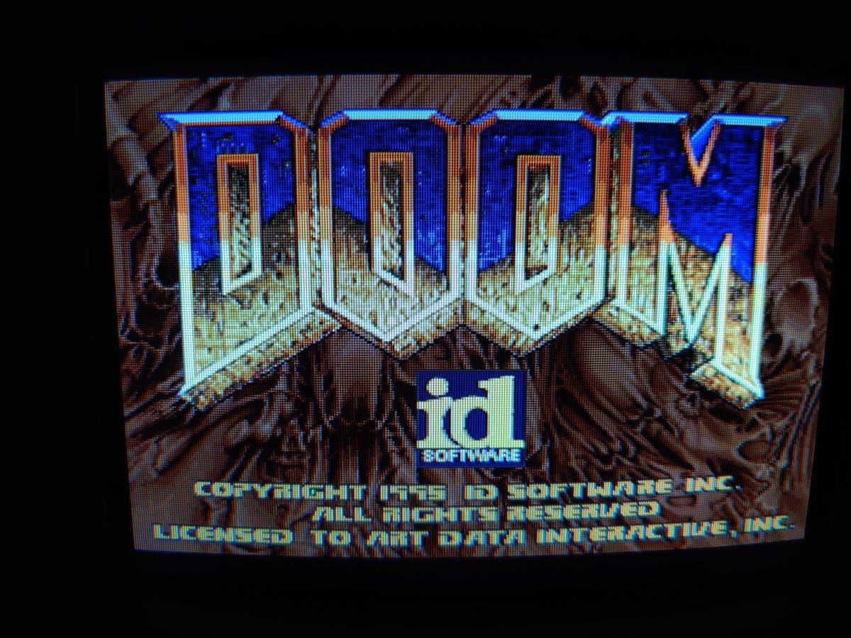 3DO Panasonic FZ-1 displaying DOOM startup screen with blue castle towers, showing restored laser functionality after PSU trace repairs and ceramic capacitor replacement.