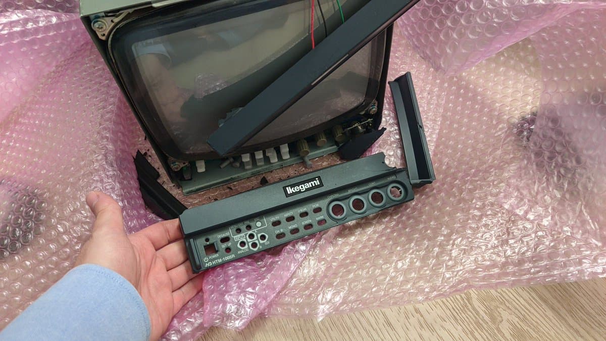 Disassembled Ikegami monitor showing shattered CRT screen and internal circuit board damage from shipping transit.