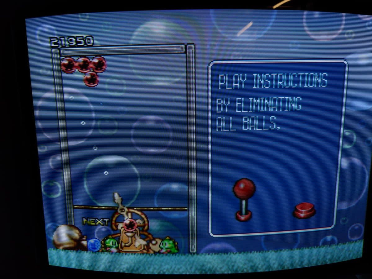 3DO Panasonic FZ-1 running Puzzle Bobble, displaying gameplay with four red balls at top and joystick/button controls on right panel.