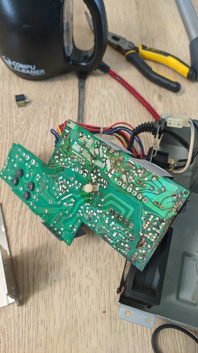 Disassembled X68000 Pro II motherboard with two PCBs showing solder joints, capacitors, and wiring during restoration diagnostics.