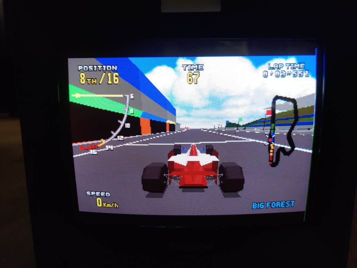 Virtua Racing Deluxe 32X gameplay on CRT: red race car at starting line, Big Forest track, 8th/16th position, 0 km/h speed.