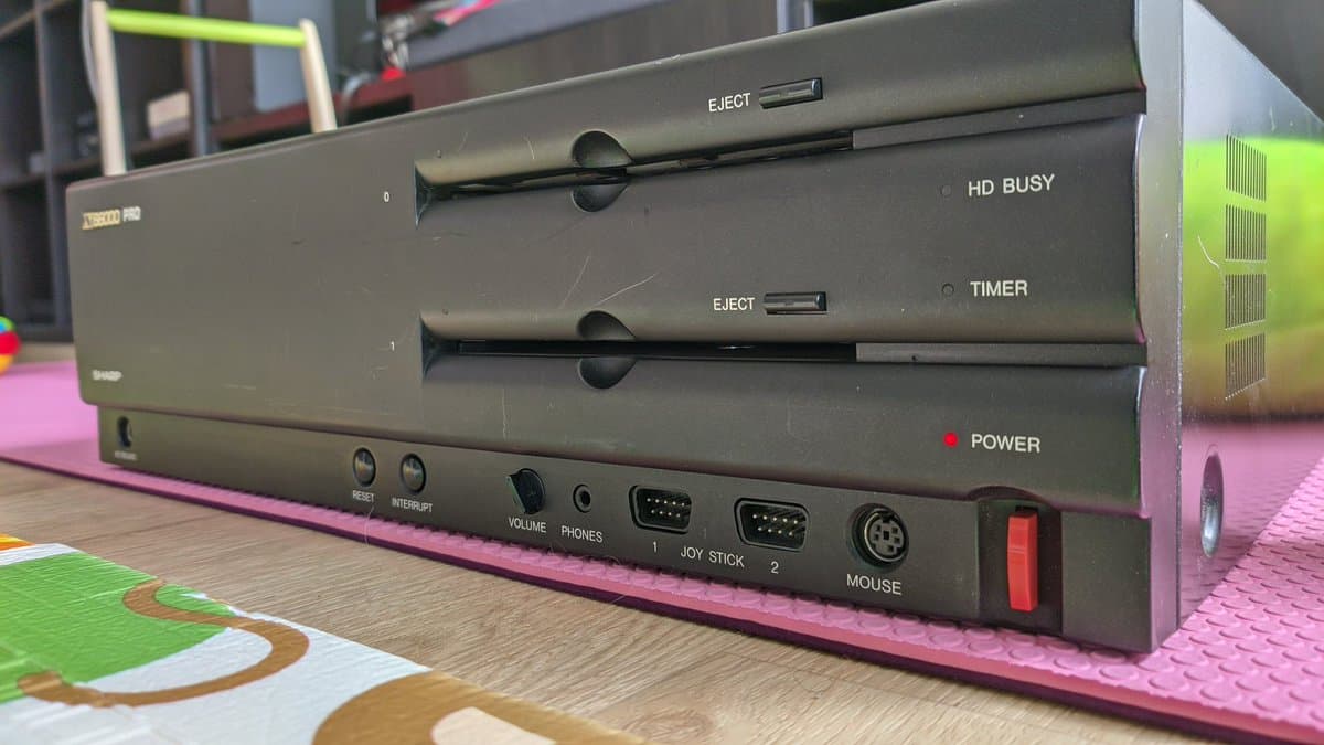 Sharp X68000 Pro II front panel showing dual 3.5" floppy drives with eject buttons, power indicator, and I/O ports during restoration.