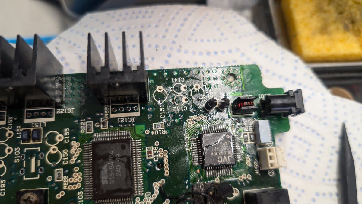 Repaired Wondermega circuit board with heatsink and components visible; solder joints and IC chips restored after corrosion damage.